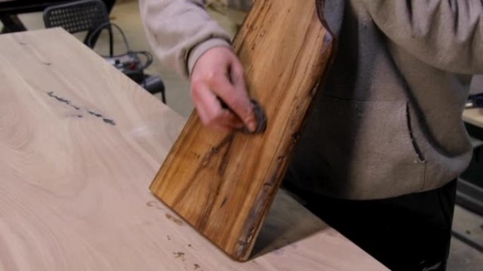 木匠用保护性亚麻籽油涂覆木制切菜板的特写