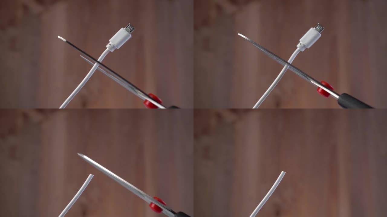 剪刀在棕色背景上切割白色微型usb电缆