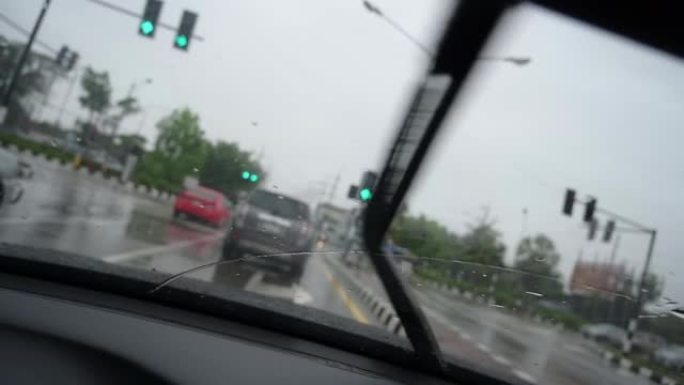 慢动作场景，雨天开车，挡风玻璃刮水器清洁挡风玻璃上的雨滴
