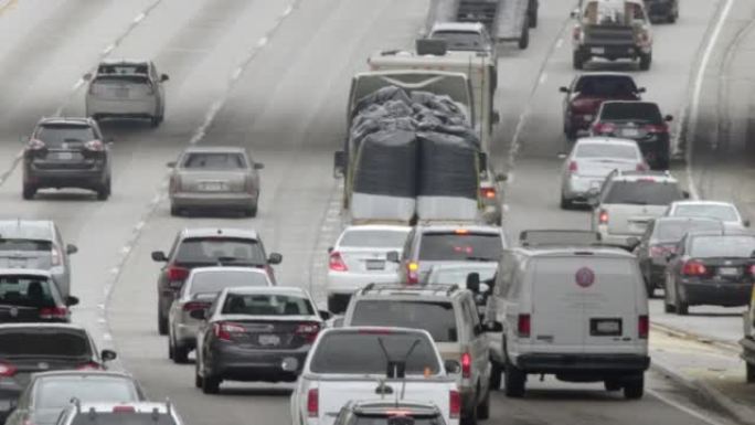 满载麻袋卡车的交通在洛杉矶4K市区的110高速公路上向北行驶