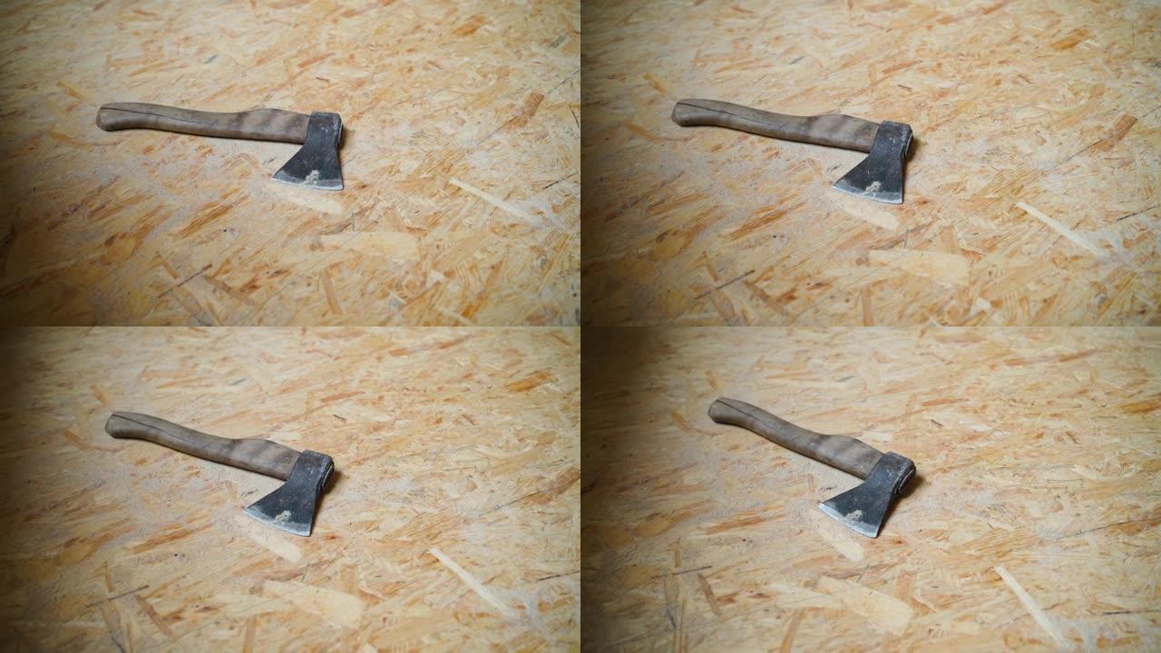 一个小斧头躺在定向的刨花板上，使相机运动平稳。调整施工现场OSB面板的尺寸