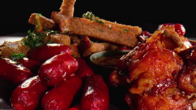 炸鸡翅和肉片配香草和红辣椒，蘸碗酱-特写