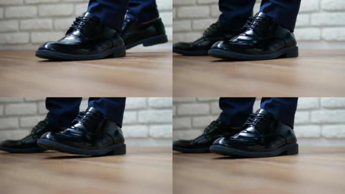 主人用脚踩在地上，男鞋是经典的黑色，男鞋是现代的。用脚敲地板。身体的语言