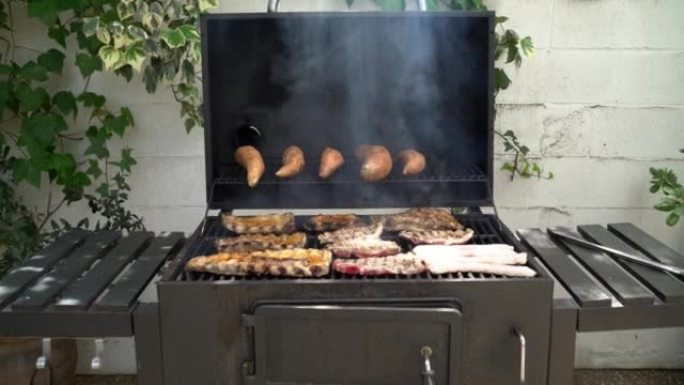 在后院的烧烤烤架上煮美味的猪排和红薯
