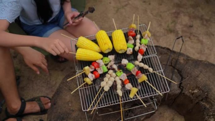 幸福的家庭小女孩一起准备烧烤，在海滩外烹饪烧烤晚餐，在海滩上享受夏天，享受周末人们的生活方式。