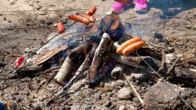 在夏季露营季节的晴天，在篝火上烧烤香肠
