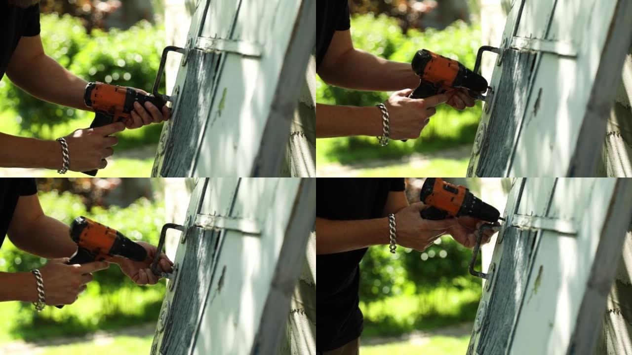 使用钻头的人从木门上取下旧的插锁，