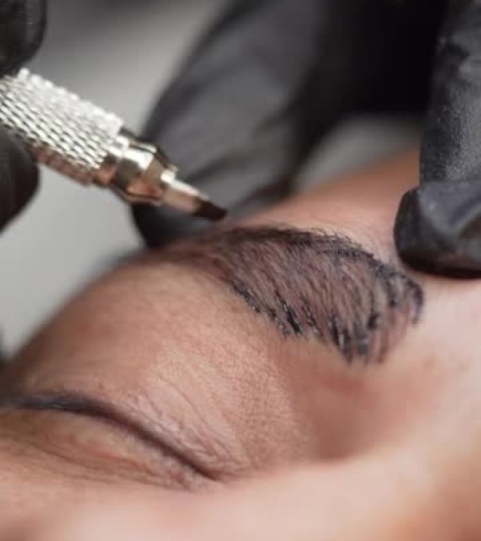 半男性面部微刀片制作永久眉毛化妆的极端特写镜头