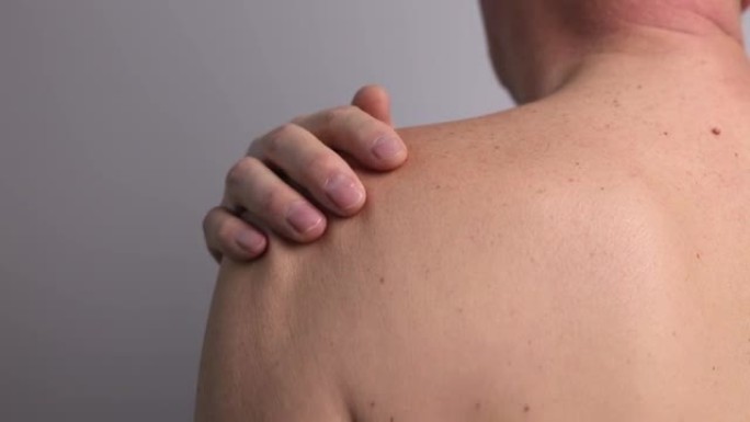 肩痛及触发点。裸男近距离按摩疼痛的肩膀。关节损伤。保健、医疗理念
