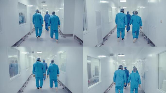医务人员戴着防护口罩，穿着制服在制药厂走廊上行走和交谈的背景图。