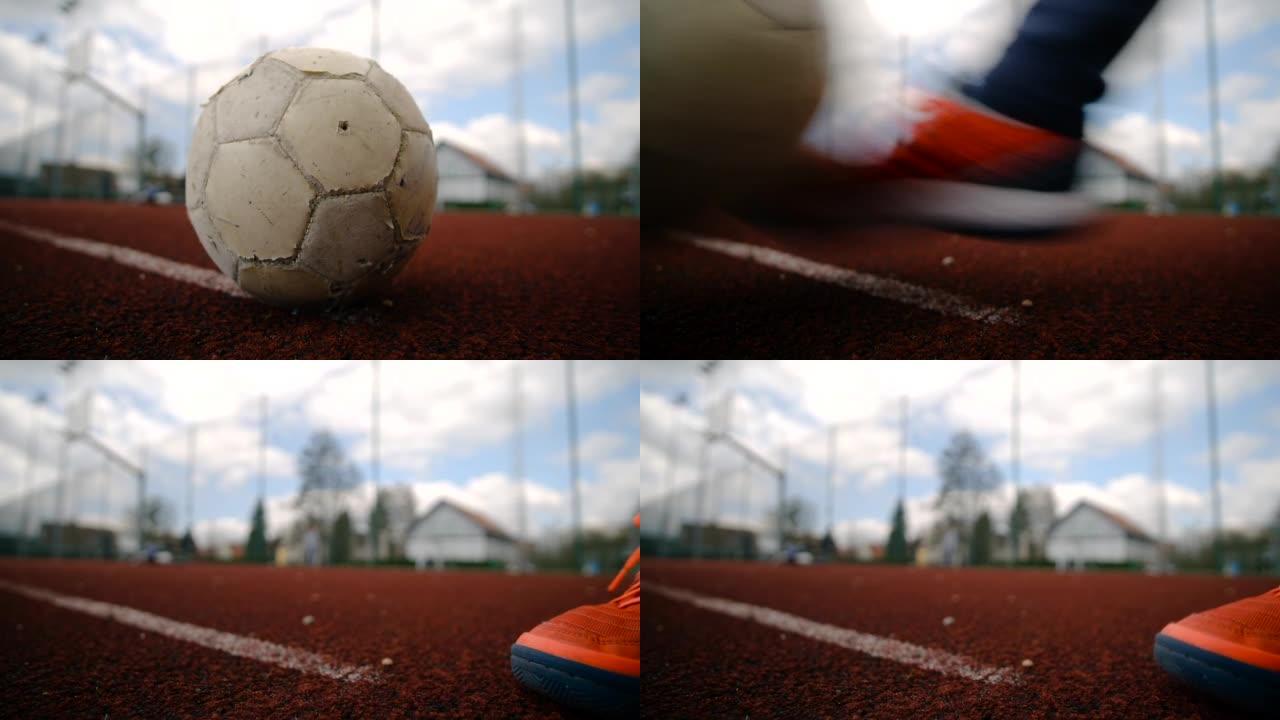 一名儿童运动员以慢动作踢足球的特写镜头
