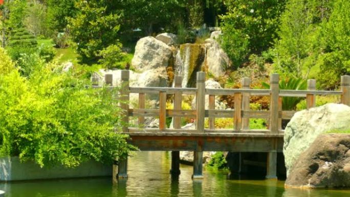 景观-在瀑布的背景下，公园中的木桥