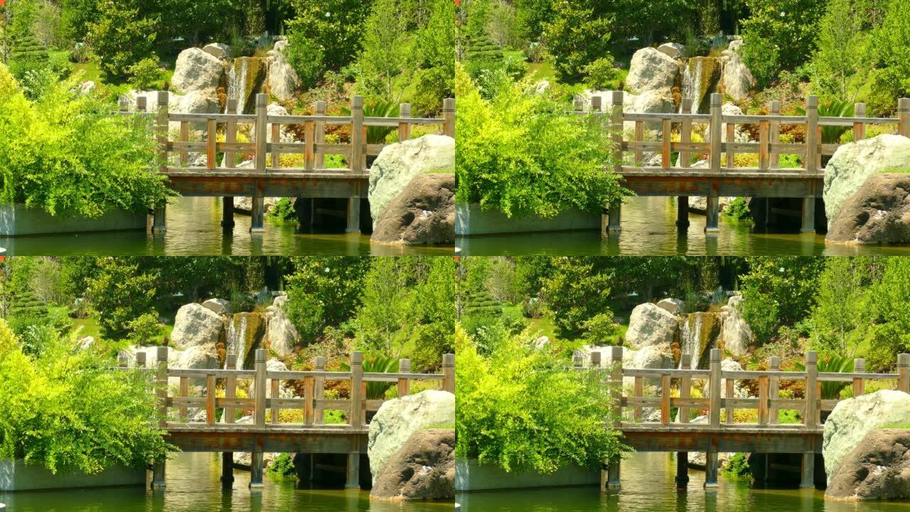 景观-在瀑布的背景下，公园中的木桥