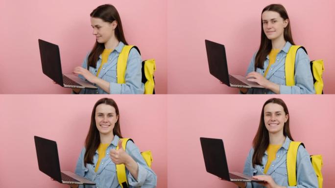 可爱的女孩的肖像青少年学生穿衬衫和黄色背包在笔记本电脑上保持使用类型的作品，显示拇指向上，孤立的粉红