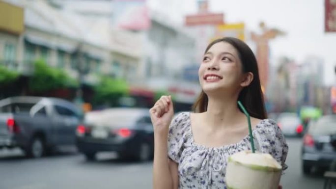 年轻迷人的亚洲女性在泰国享受街头美食。泰国美食概念。亚洲食品概念