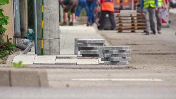 建筑工人在人行道改造道路工程中铺设混凝土石板