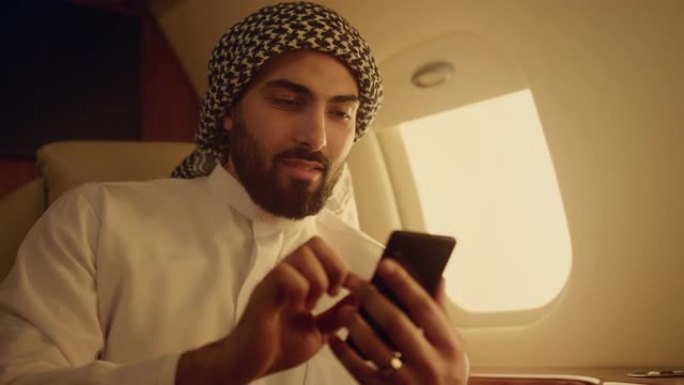 富人在旅行特写中寻找智能手机。微笑的阿拉伯触摸屏