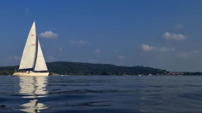 在意大利马焦雷湖平静开放的湖水中航行的小船的慢动作和低角度视图