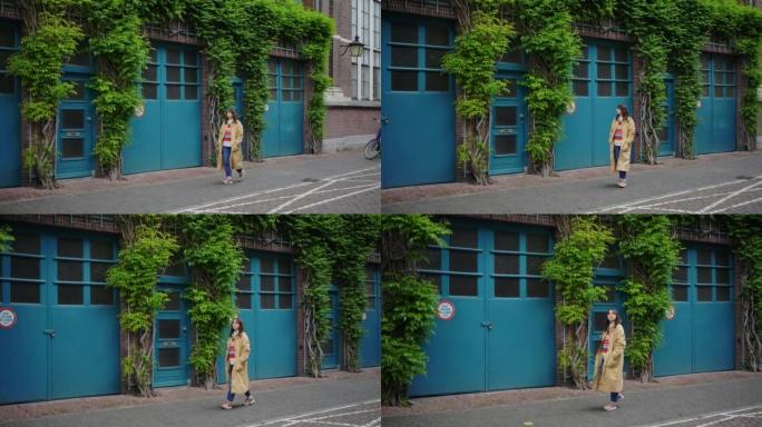 女人走在蓝色门窗的建筑物附近