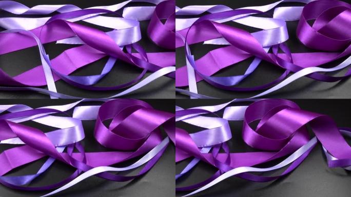 缎子紫色丝带躺在黑色背景上