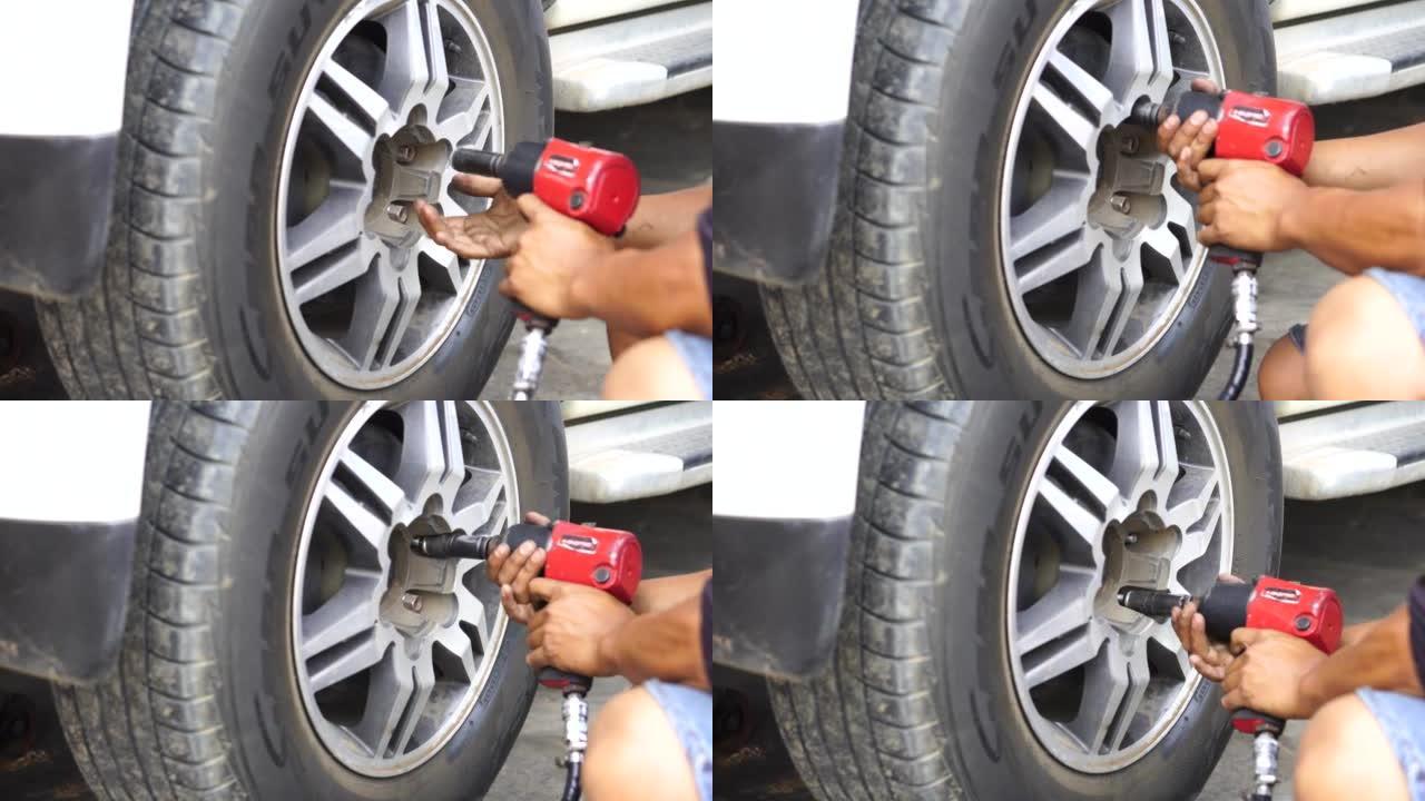 一名熟练的机械师正在修理厂更换车轮平衡器上的轮胎。