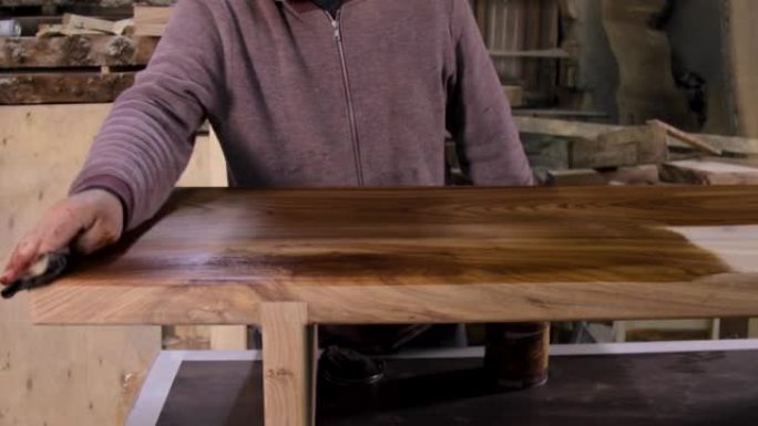 木匠在木桌上涂上保护性亚麻籽油