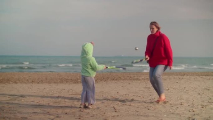 孩子和妈妈在海边打沙滩网球