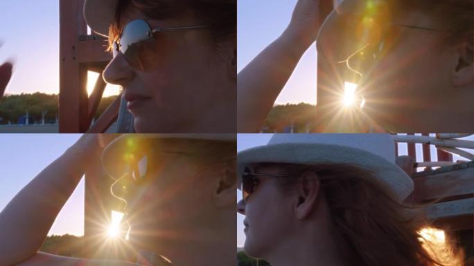 夏日日落时，一个女人在海滩上的特写镜头，头发在风中吹，阳光，电影拍摄
