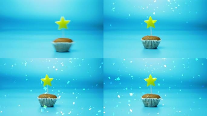 节日烘焙纸杯蛋糕，蓝色背景上有一支燃烧的星星形状的蜡烛。生日快乐或其他节日背景
