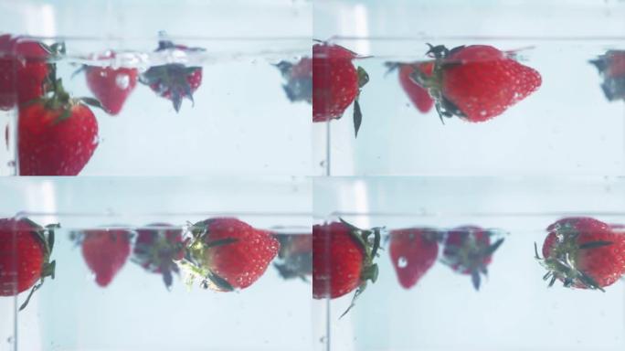 草莓溅入水中，漂浮在水下
