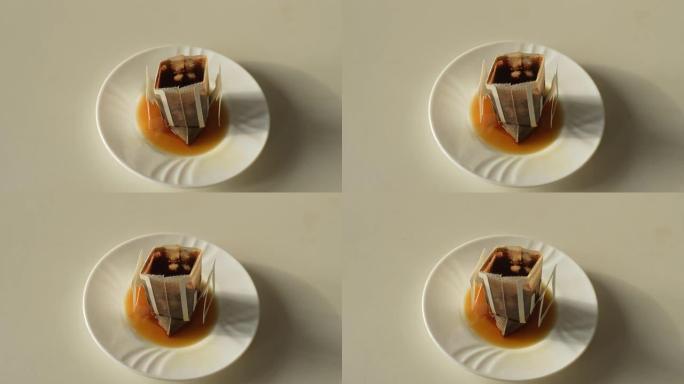 用过的滴水袋的特写高角度视图，用于在碟子中替代天然咖啡的酿造。桌子上用过的咖啡滴水袋的特写跟踪照片。