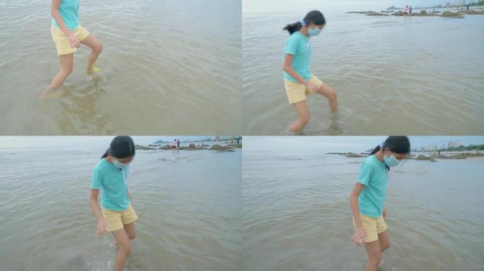 亚洲女孩戴着口罩在冲浪前在海滩上放松，生活方式理念。