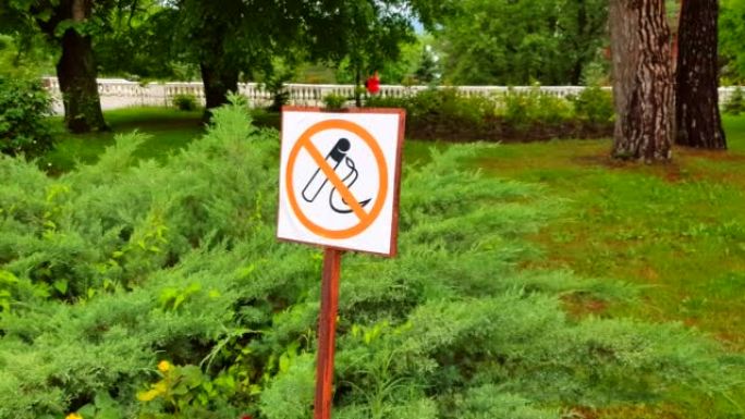 4k视频，在小巷和树木的背景下的夏季公园中禁止吸烟的标志，在公共场所禁止吸烟的概念