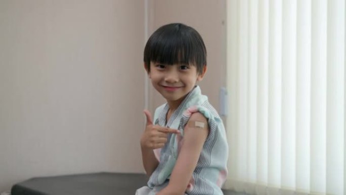 快乐男孩在接种疫苗后微笑并缠绕在手臂上