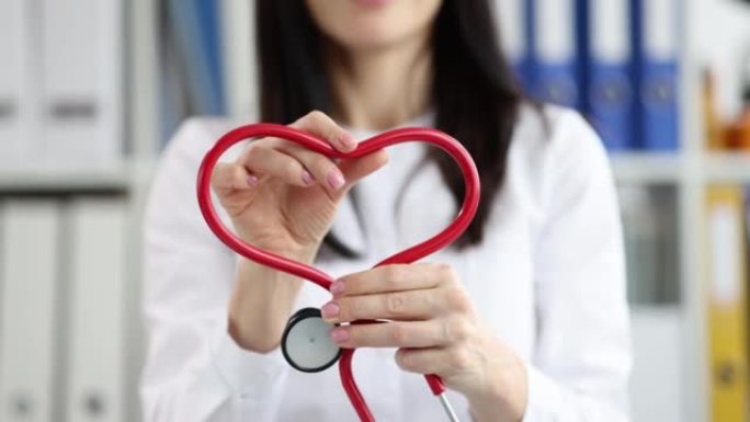 A cardiologist folds a stethoscope into a heart sh