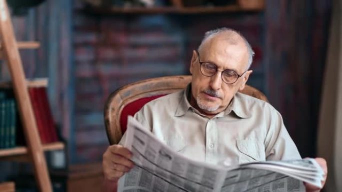 白发老成熟男人戴眼镜阅读日报印刷报纸复古扶手椅