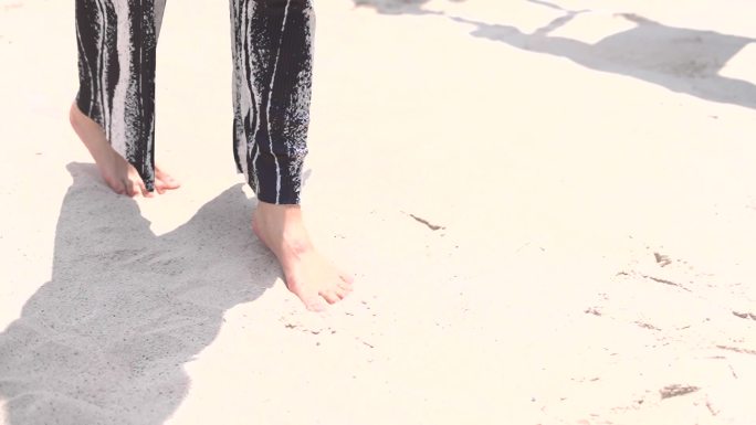 女孩光脚在沙滩玩沙跳跃脚特写