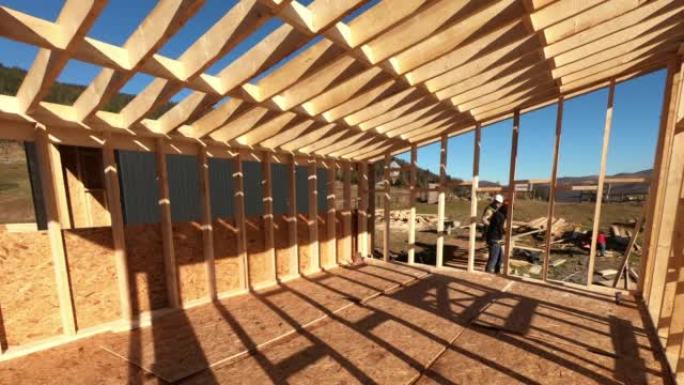 木匠在未来木结构小屋的墙上安装OSB面板的时间流逝。