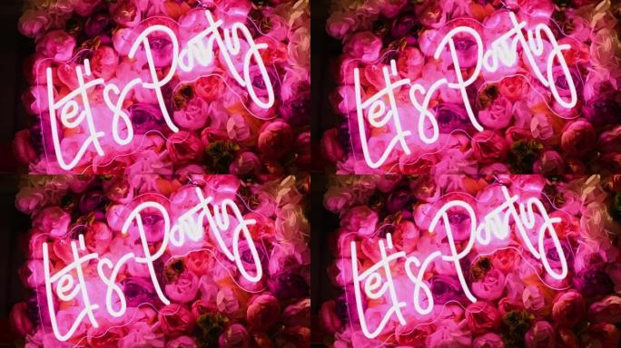 让派对发光霓虹粉色标志，背景上有鲜花