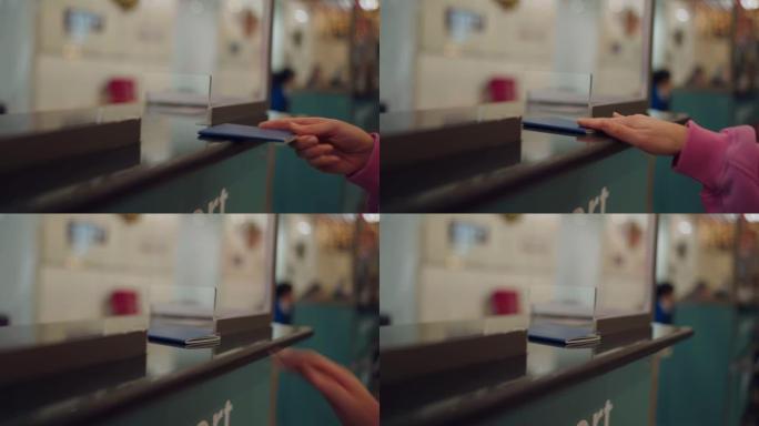 女性手将护照放在机场的收银台特写镜头。游客手将蓝色护照放在机场的柜台上。旅游概念。移居国外的概念。