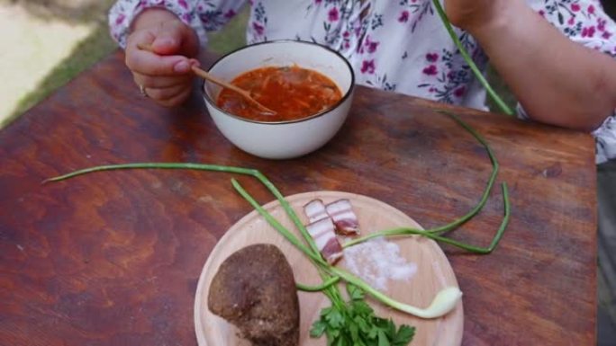 女性游客在户外享用午餐，吃乌克兰国菜 -- 罗宋汤