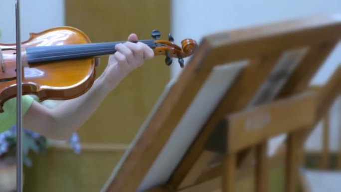 孩子在学校音乐课上练习拉小提琴。