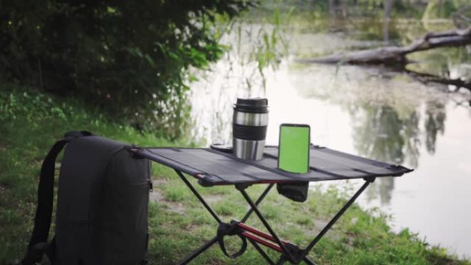 户外带保温杯和智能手机的野营桌