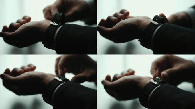 穿着经典蓝色西装的自信商人穿着或调整酒店房间窗户附近的领带手表。英俊的男人在婚礼上穿着漂亮的西装。