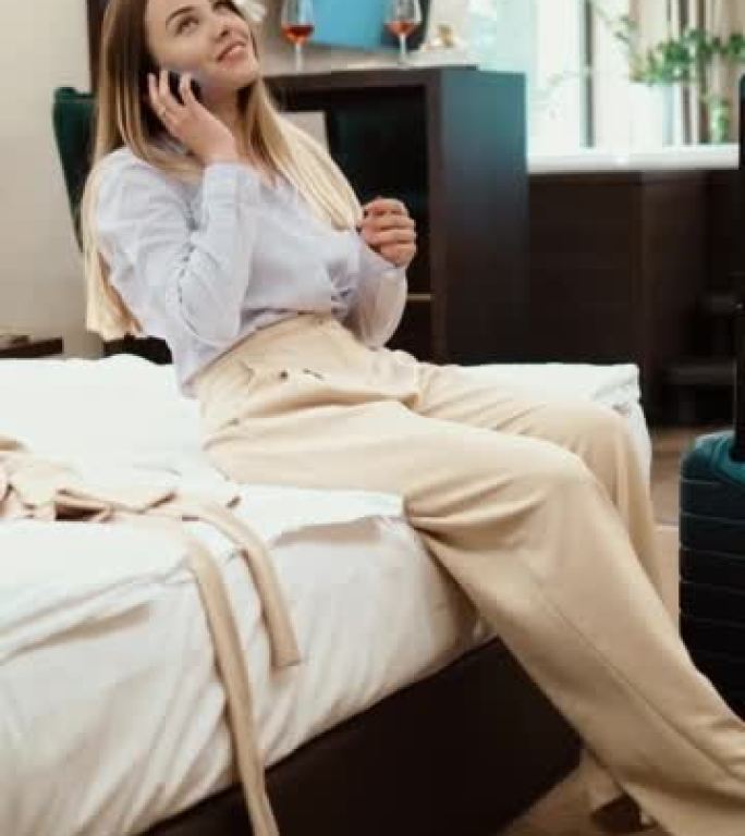 精疲力竭的商务小姐脱下鞋子，躺在酒店房间的床上打电话。垂直射击