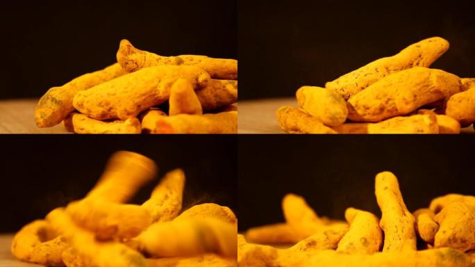 干姜黄从上面落在木桌上，整个姜黄手指或棍子上，姜黄干根掉落