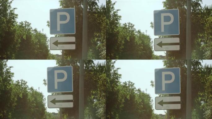 在阳光明媚的夏日，指示方向的停车路标立在街道上。