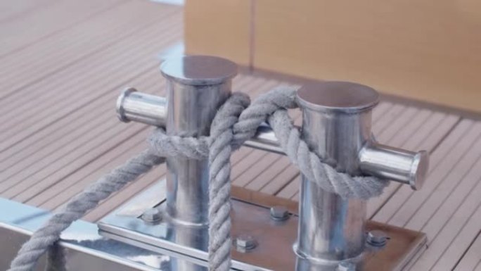 扭曲的结使船在码头上。钢柱上的系泊绳。