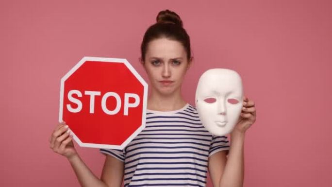 手持白色口罩的女子对着镜头示意停止，并点头表示不，不要改变个性。