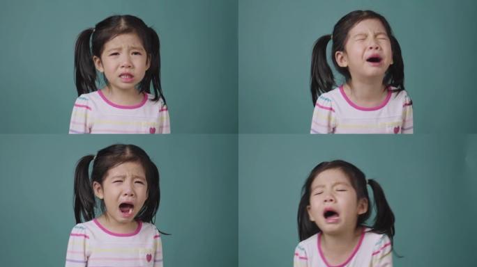 亚洲小女孩哭泣的肖像在蓝色背景上泪流满面，学校孩子的教育理念
